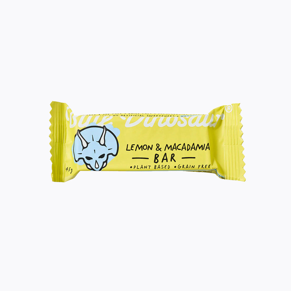 A packaged snack bar with 'Blue Dinosaur' branding, lemon & macadamia flavor, and an illustration of a dinosaur on the wrapper.