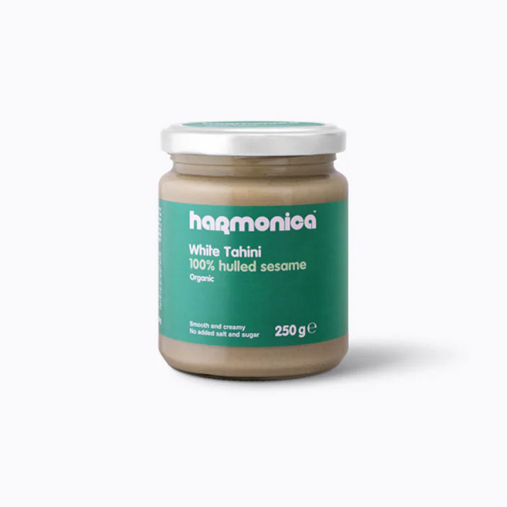 A jar of Harmonica brand White Tahini, which is labeled as 100% Hulled Sesame, 250g.