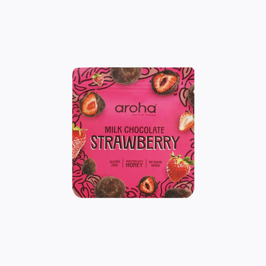 Aroha Milk Chocolate Strawberry snack pouch on a light gray background. The packaging is bright pink with illustrations of strawberries, chocolate pieces, and the brand name 'aroha' in the center.