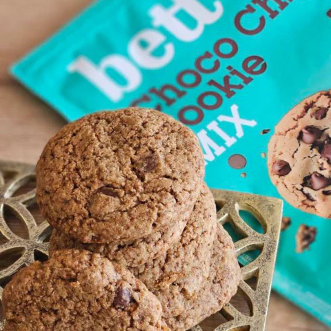 Chocolate chip cookies on a decorative plate with a teal box labeled 'betta Choco Cookie Mix' in the background.