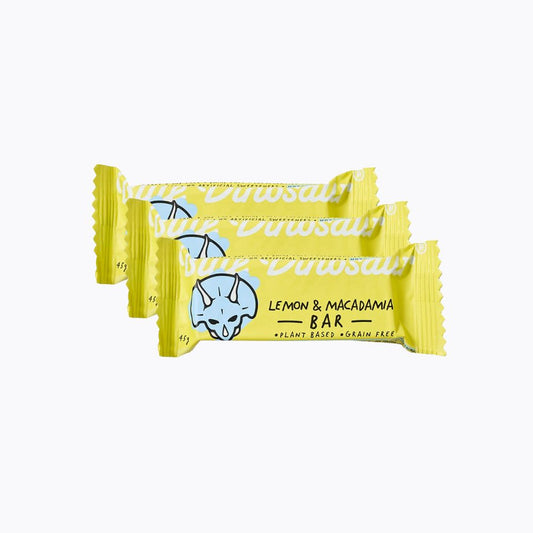 Two lemon and macadamia nut bars in yellow wrappers on a white background