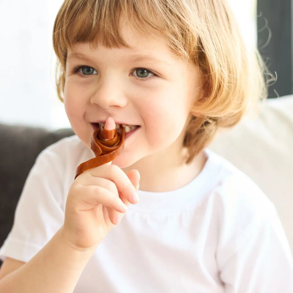 Child eating a chocolate bar with a blurred background