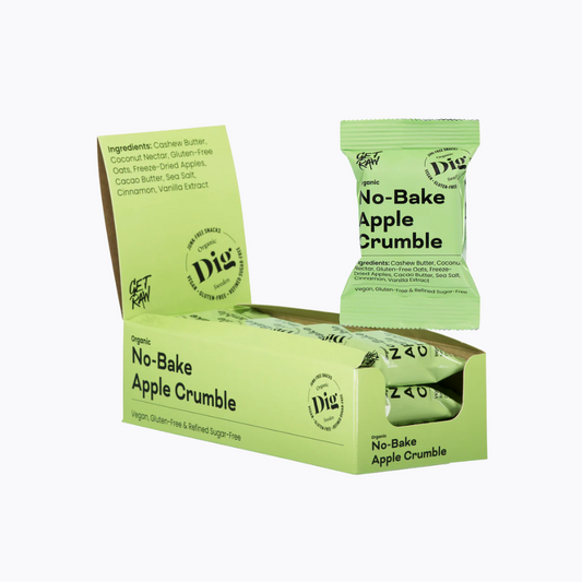 Box of no-bake apple crumble bars with a single bar on a white background
