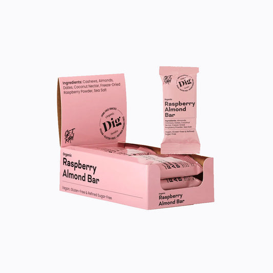 A pink retail display box and individual packet of Dig Foods Organic Raspberry Almond Bar on a clean white background.