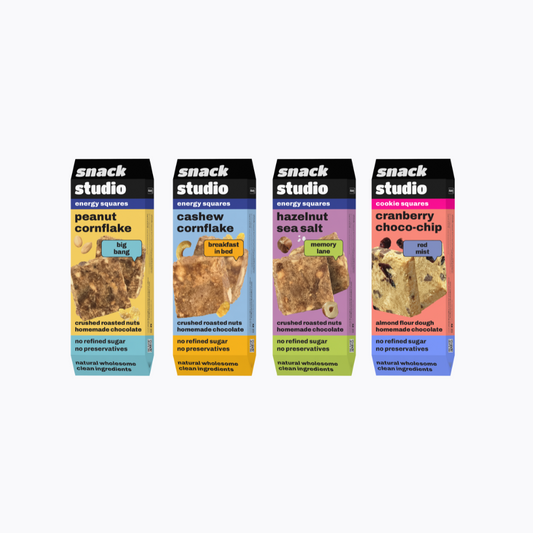 Four boxes of snack studio energy squares on a white background