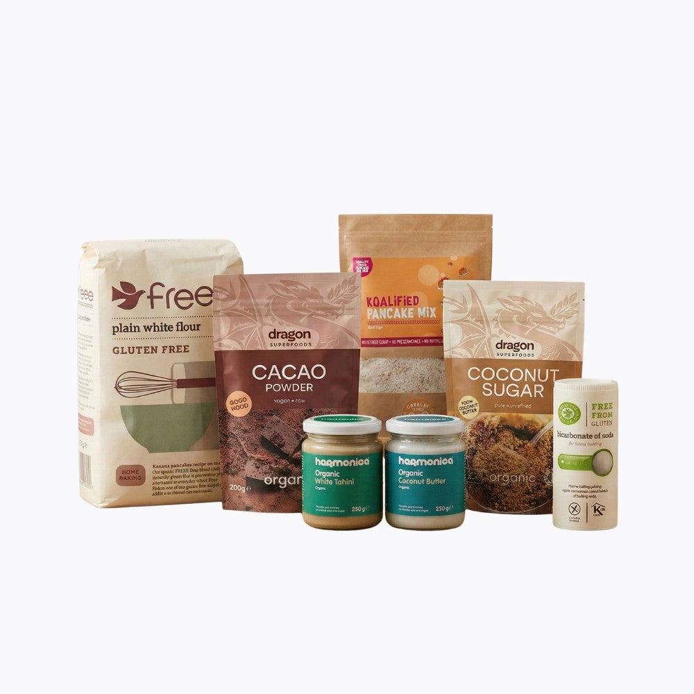 Assorted baking ingredients including flour, cacao powder, and coconut sugar on a white background