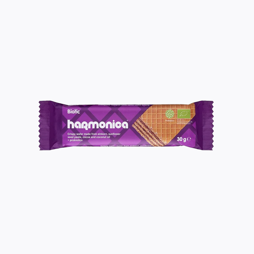 A packaged biotic wafer snack with einkorn and probiotics, 30g, branded as 'harmonica' with a purple color scheme and organic certification.