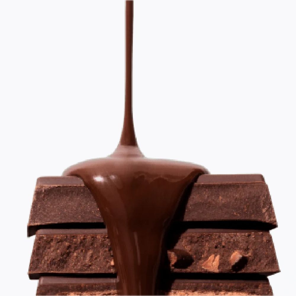 Chocolate being poured over a stack of chocolate bars on a white background