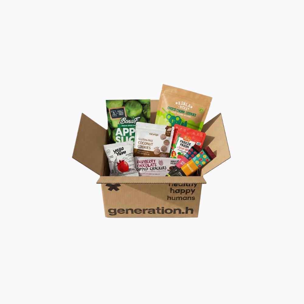 A Generation Happy Humans cardboard gift box filled with assorted packaged snacks and healthy foods, photographed on a plain white background.