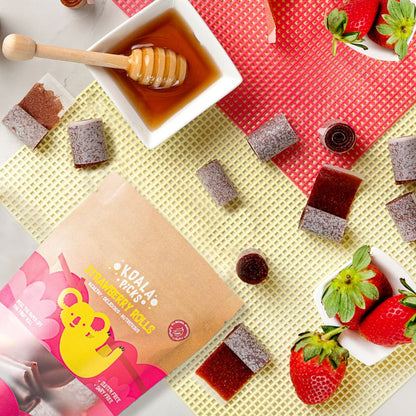 Kola Pops strawberry rolls packaging with honey, strawberries, and a dipper on a colorful background.