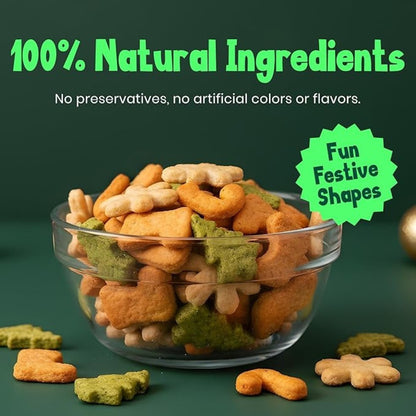 Glass bowl filled with dog treats in fun festive shapes on a green background with text about natural ingredients.