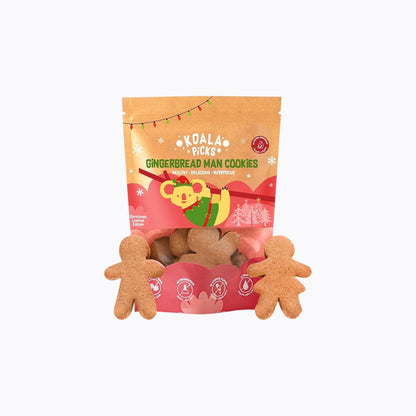 Packaged dog treats shaped like gingerbread men with a festive design on the packaging.