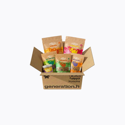A cardboard gift box filled with assorted pet treats and pouches from Generation H, photographed on a clean white background.