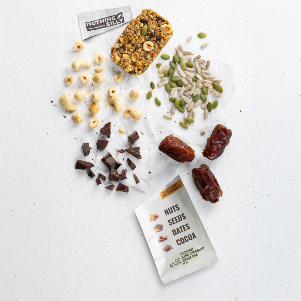 Nuts, seeds, dates, and a bar with 'Nothing Filly' branding on a light background