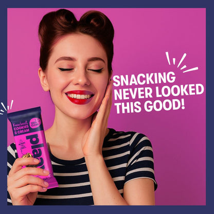 Woman holding a pink snack package with text 'Snacking never looked this good!' on a purple background