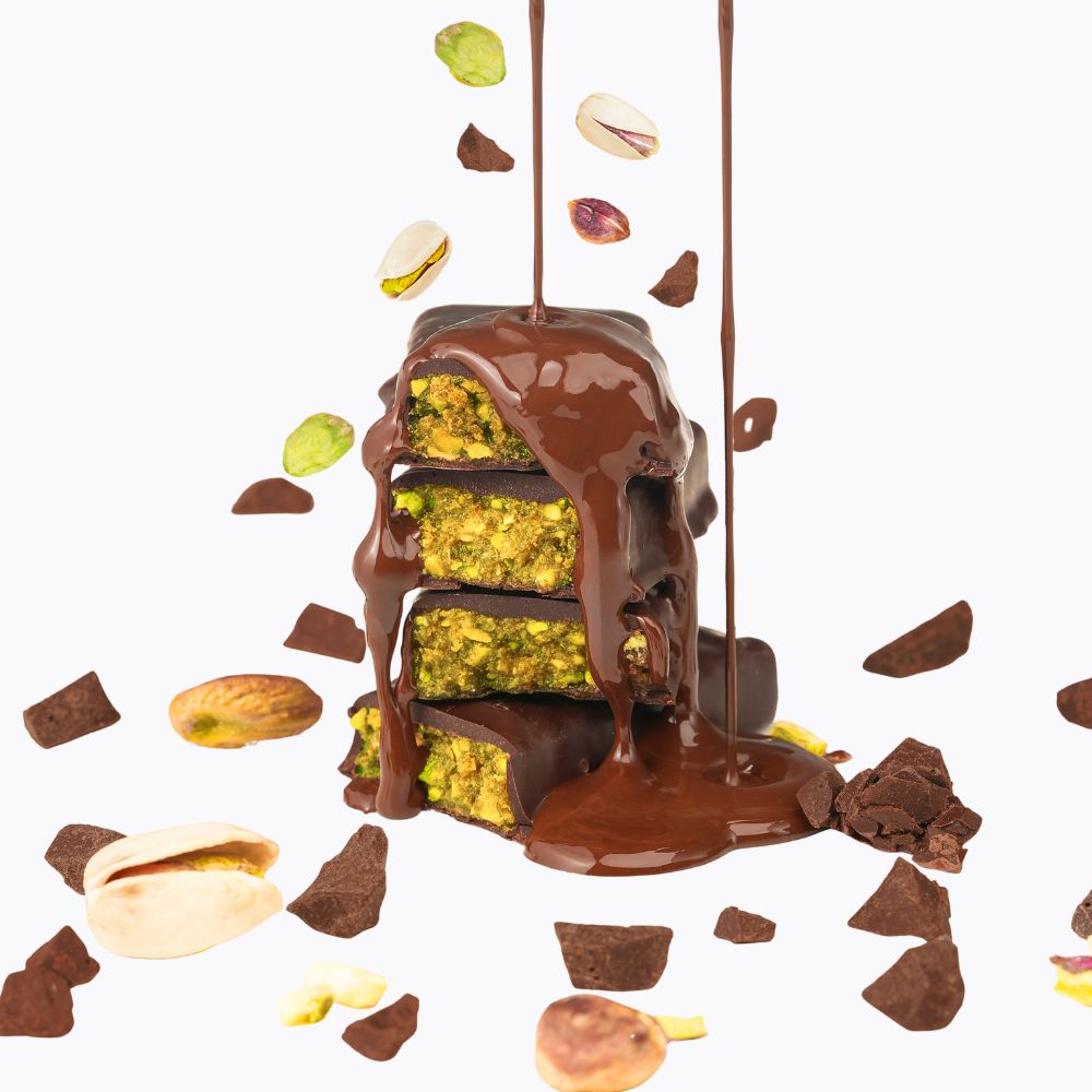Chocolate-dipped treats with pistachios on a white background