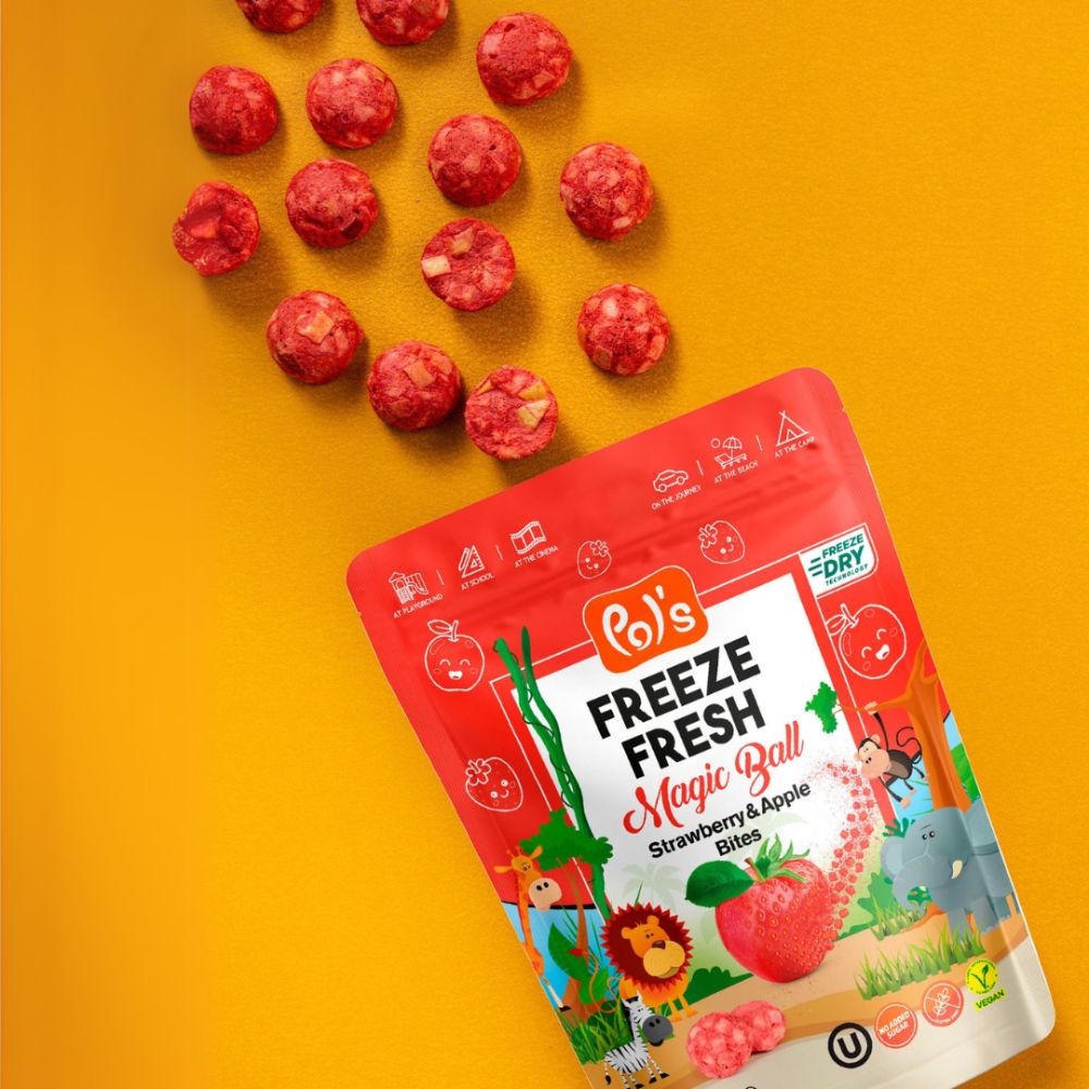 Red package of 'Pol's Freeze Fresh Magic Ball' on a yellow background with freeze-dried strawberry and apple bites.