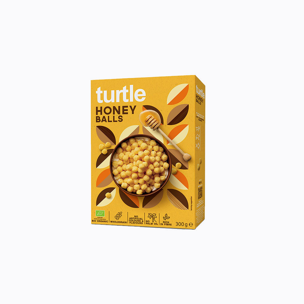 A 300g box of turtle Honey Balls cereal on a plain white background. The packaging is a warm golden yellow with illustrations of honey pots, a wooden honey dipper, and a bowl of honey balls.