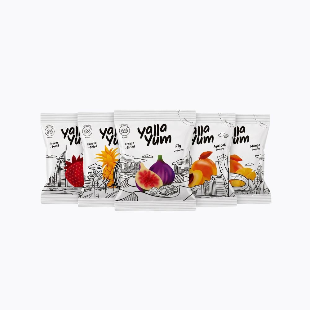 Five Yalla Yum flavor snack pouches arranged in a fan shape on a plain white background. The white packaging features black line art and colorful illustrations of different fruits, including strawberry, fig, apricot, and mango.