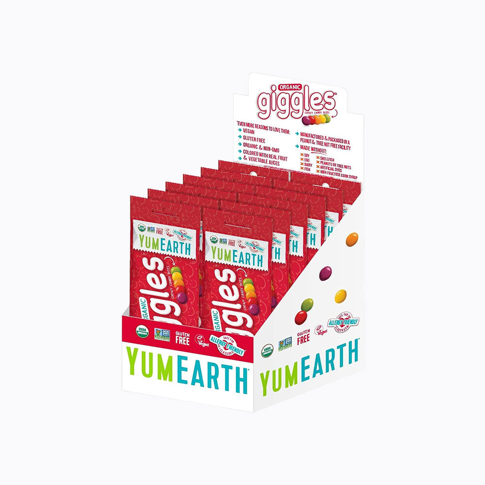 A YumEarth Giggles candy display box filled with individual red candy bags, shown on a plain white background.