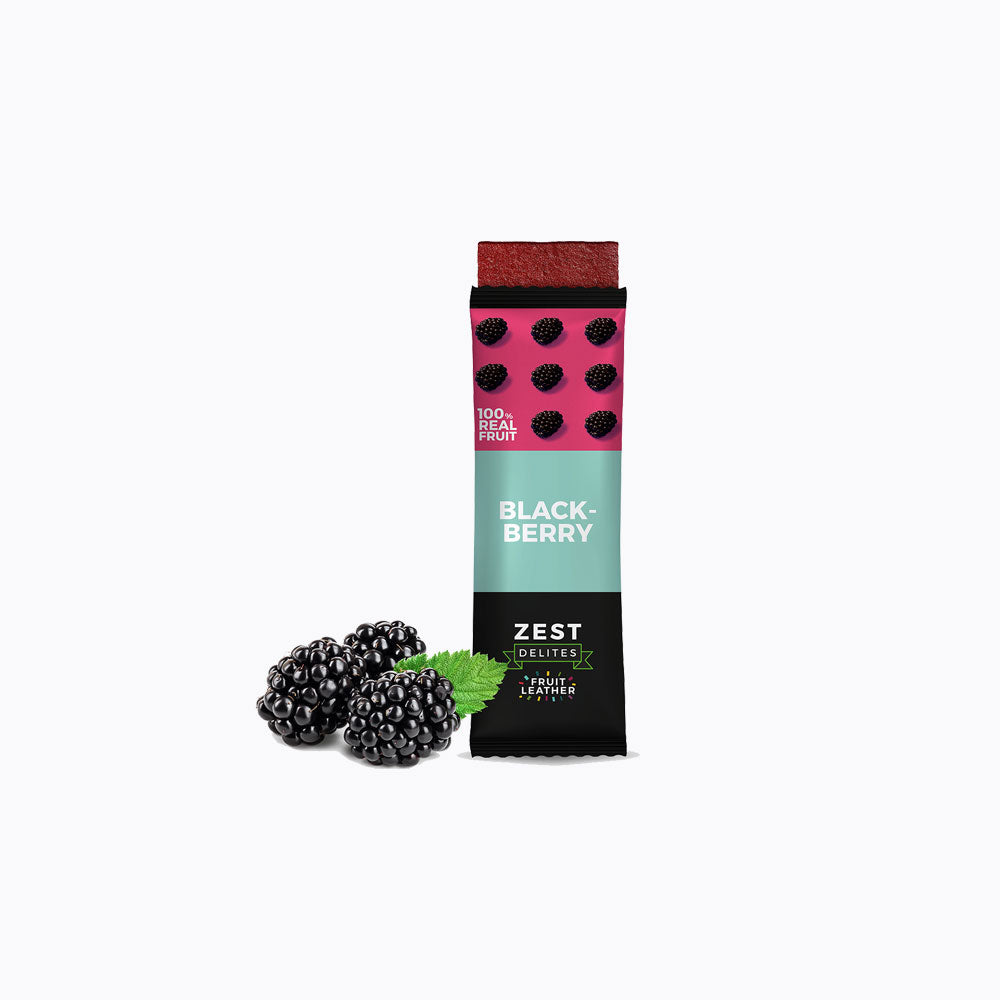 A 24-pack display box of Zest Zestix Mango Apple Based Dried Fruit Bars, featuring multiple individually wrapped bars fanned out from a black cardboard tray with fruit illustrations and a few fresh mangoes and an apple on a white background.