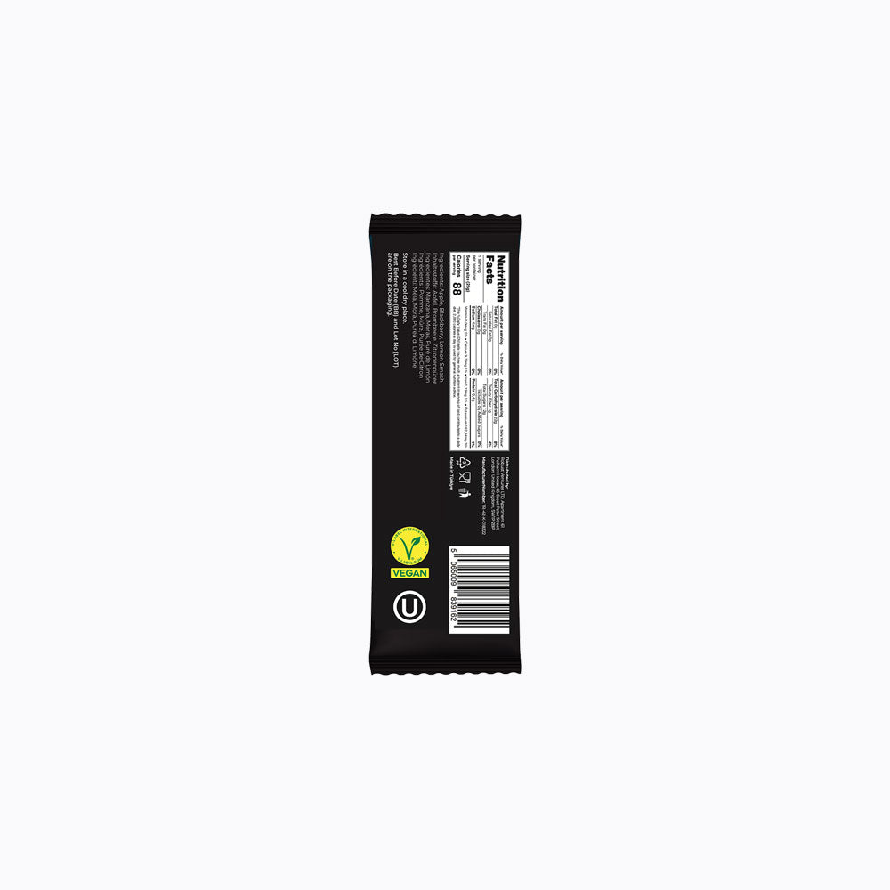 The back of a packaged snack bar, showing nutrition facts, a barcode, and certification logos including Vegan and UT, on a solid black wrapper against a light gray background.