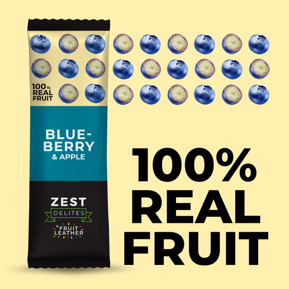 A packaged snack bar labeled 'BLUE-BERRY & APPLE' by Zest Delites stands on a pale yellow background beside repeated blueberry illustrations and large text reading '100% REAL FRUIT'.