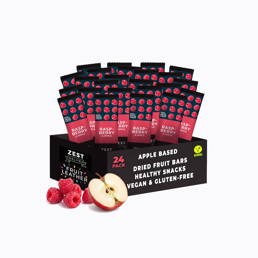 A 24-pack display box of Zest Zestix Mango Apple Based Dried Fruit Bars, featuring multiple individually wrapped bars fanned out from a black cardboard tray with fruit illustrations and a few fresh mangoes and an apple on a white background.