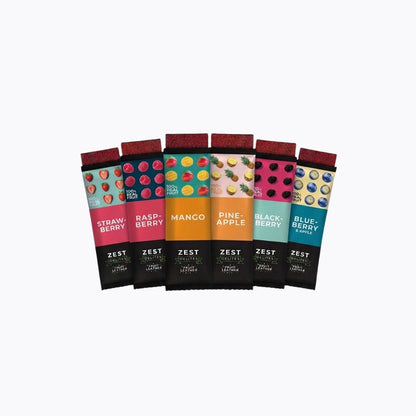 Six Zest Energy bars in individual packaging, arranged in a fan shape against a plain white background. The flavors shown are Strawberry, Raspberry, Mango, Pineapple, Blackberry, and Blueberry, each with its own vibrant color-coded wrapper and dark chocolate bar visible.